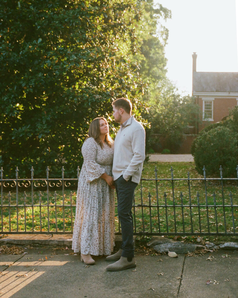 husband and wife share loving look at sunset in downtown huntsville al