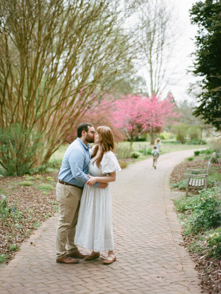A couple kisses just before their Huntsville Botanical Garden proposal