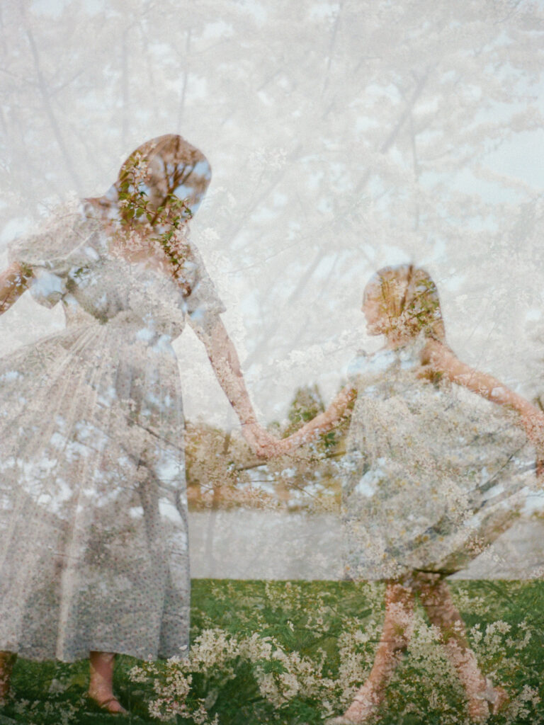 A double exposure of a flowering tree and a mother and daughter holding hands and dancing at the Huntsville Botanical Garden