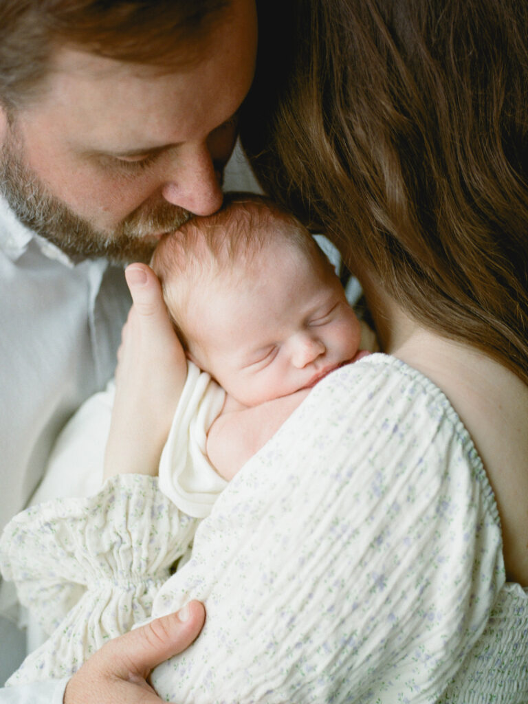 A closeup of a couple holding their newborn baby son during their session with Huntsville maternity and newborn photographer Fauna & Film