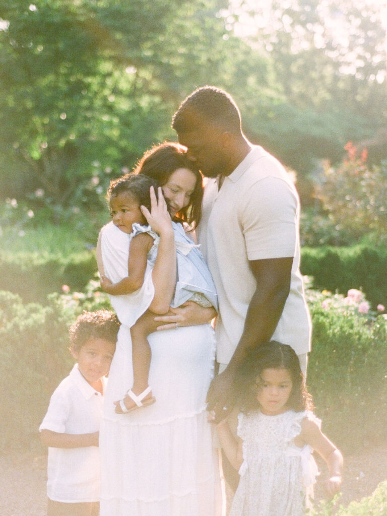 family embraces in rose garden in delano park rose garden by fauna & film