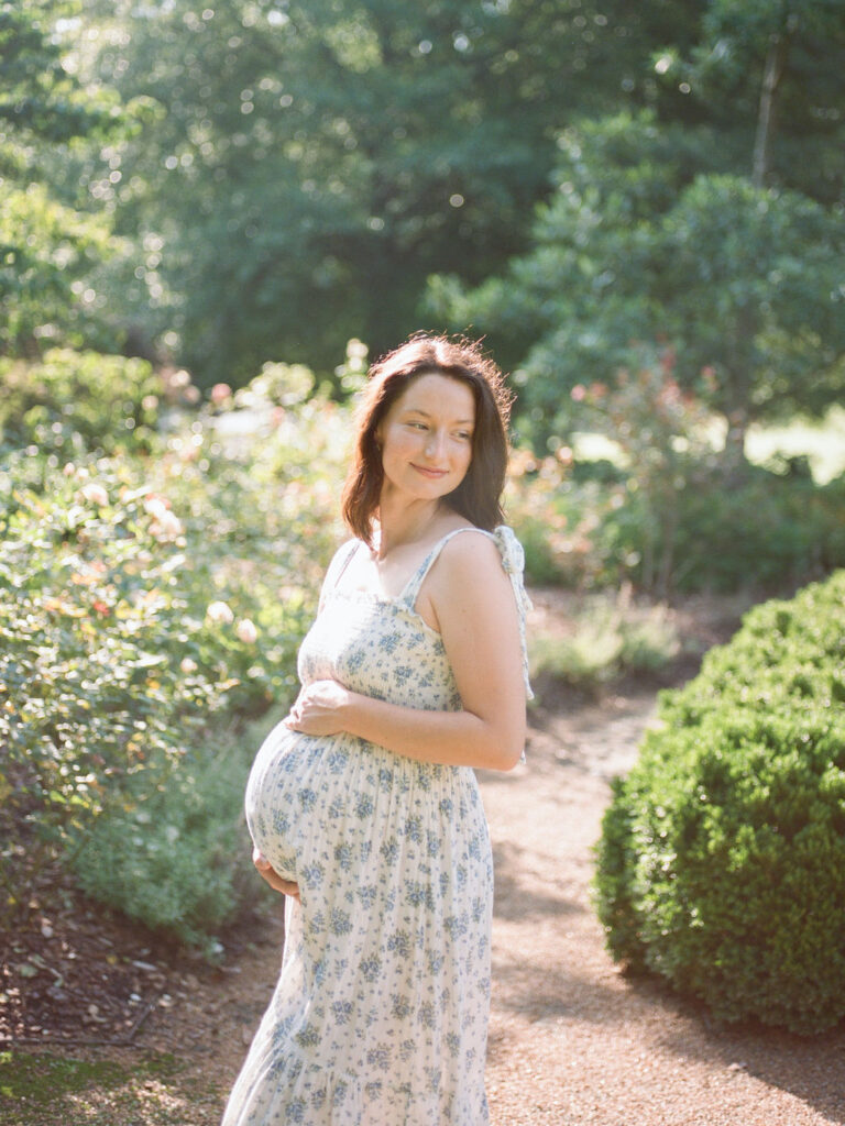 pregnant mother poses in floral gown for her huntsville maternity photography session by fauna & film