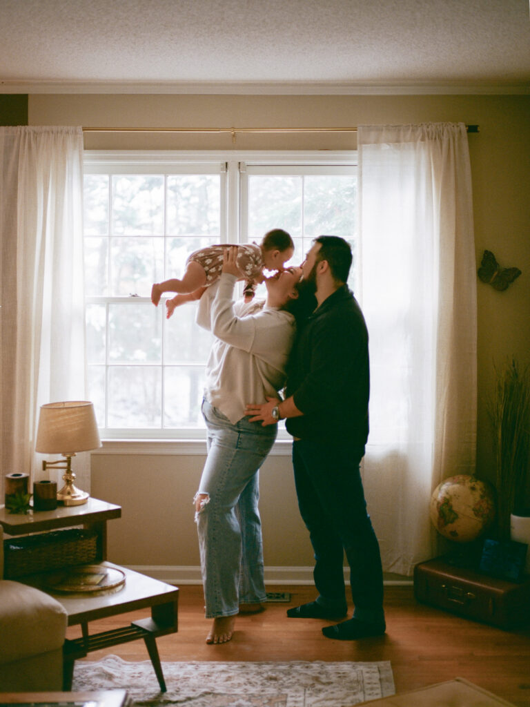 Parents pose with their baby during family photos at home
