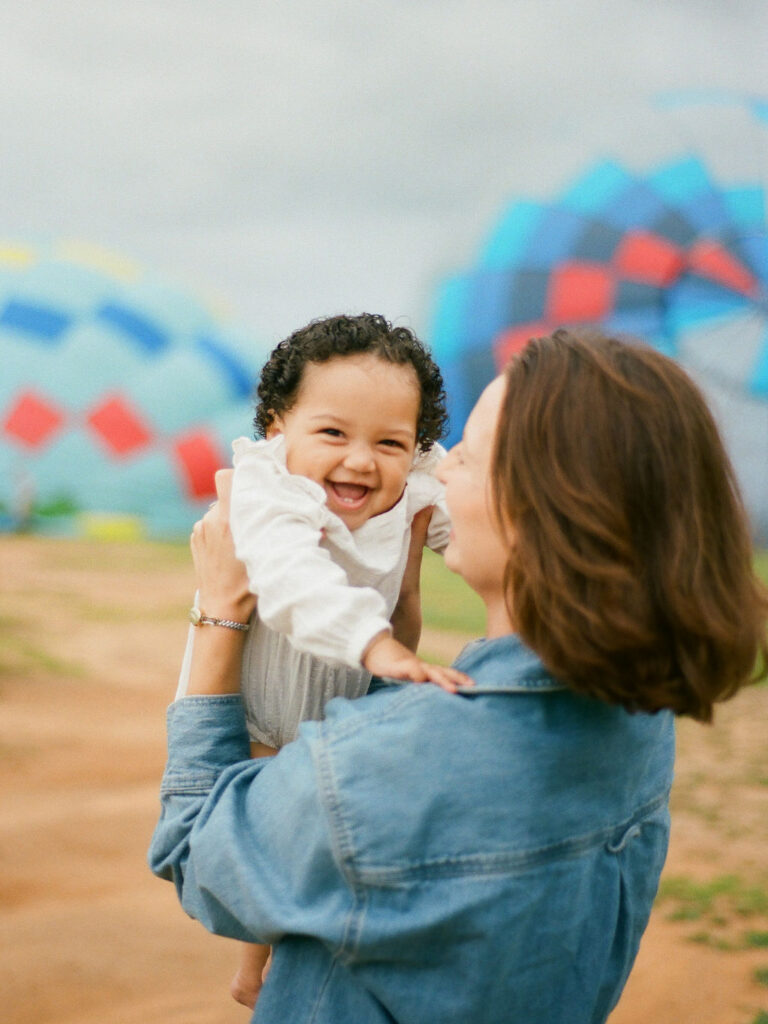 mother holds baby daughter during hot air balloon family photo session