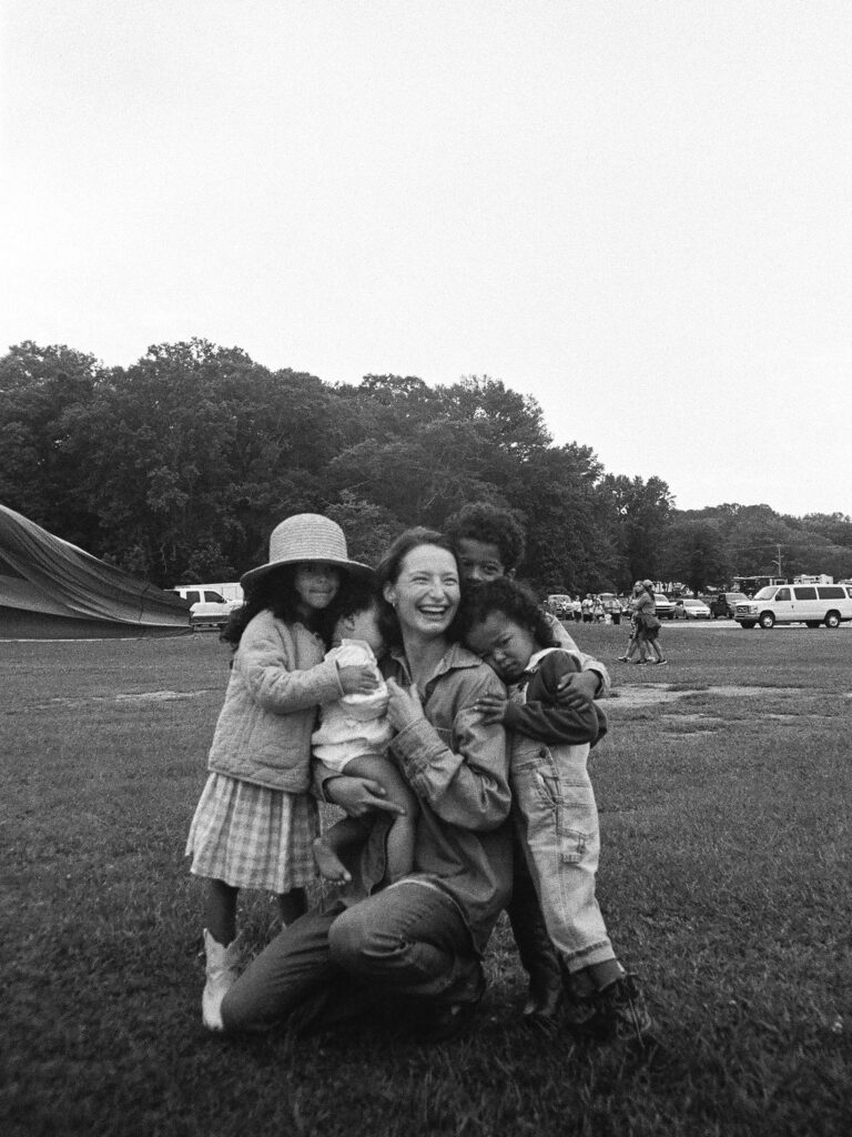 mother smiles as she's hugged by her children