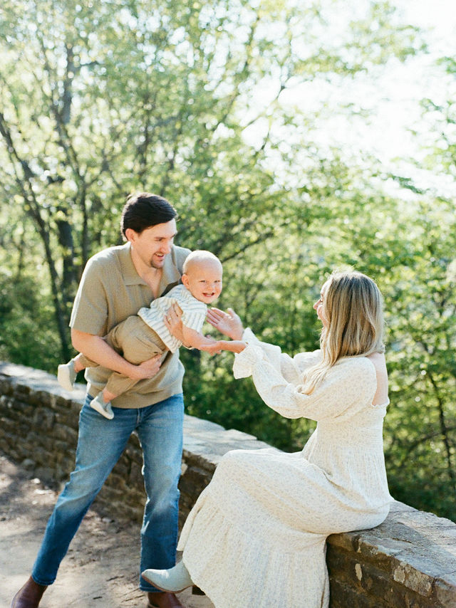 couple plays with toddler baby at overlook on monte sano mountain in huntsville al