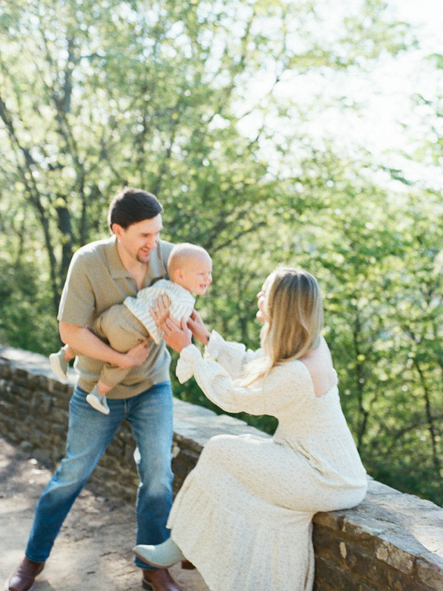 couple plays with toddler son at monte sano overlook from a north alabama family photographer
