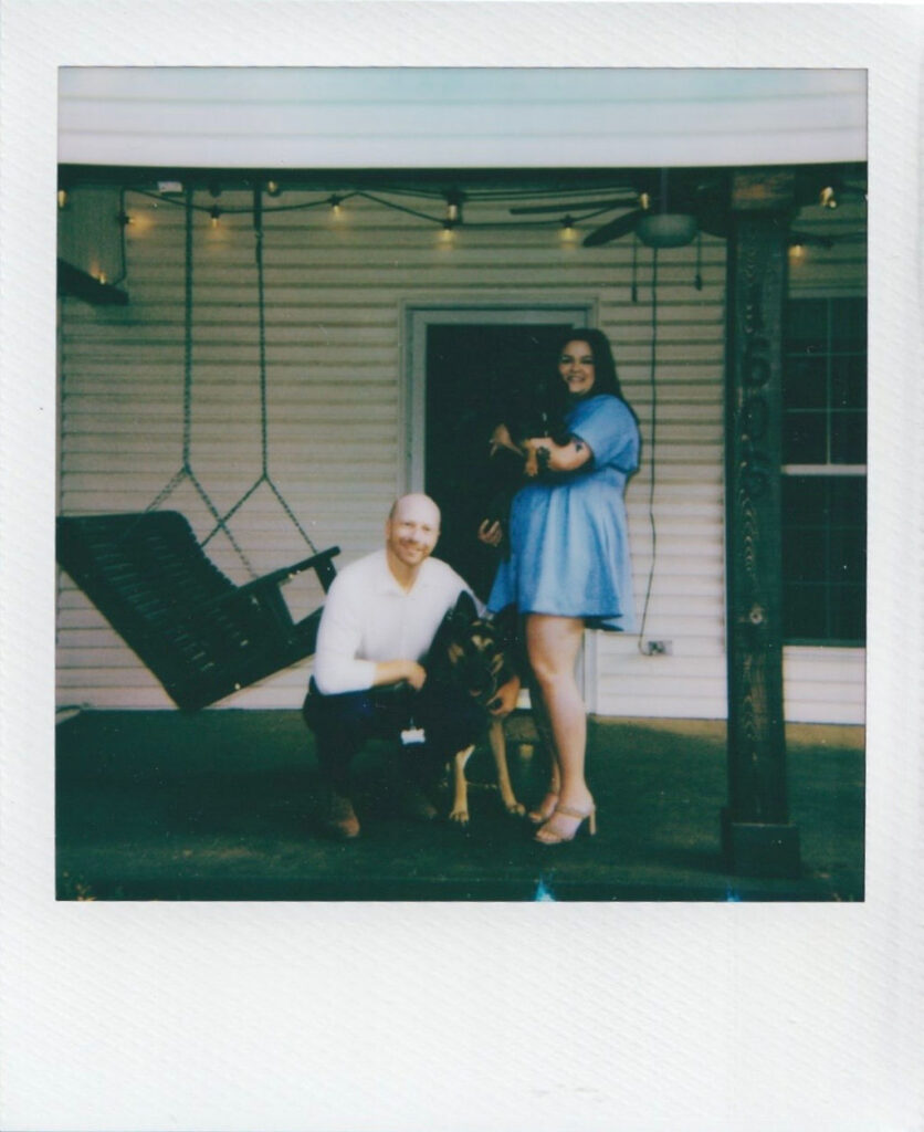 polaroid, a couple poses on their porch with their two dogs
